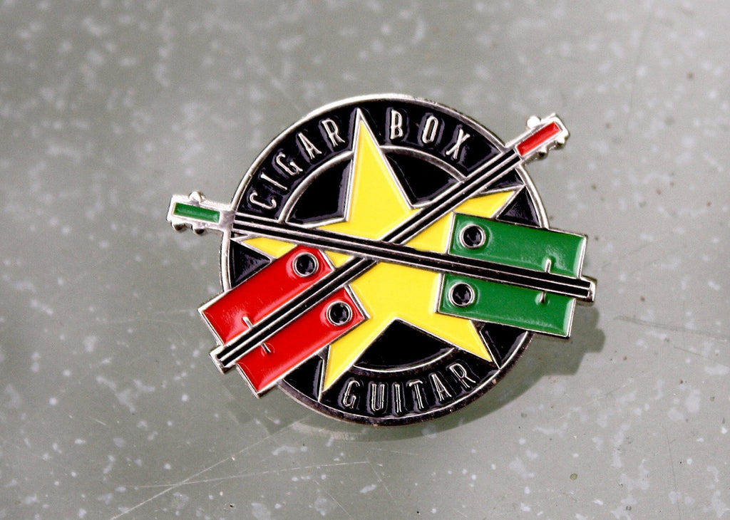 Cigar Box Guitar metal pin badge, nickel plated with coloured enamel.